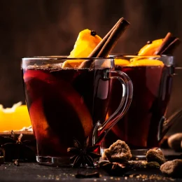 Hot mulled red wine with spices and fruits on wooden rustic table. Traditional Christmas hot drink, copy space